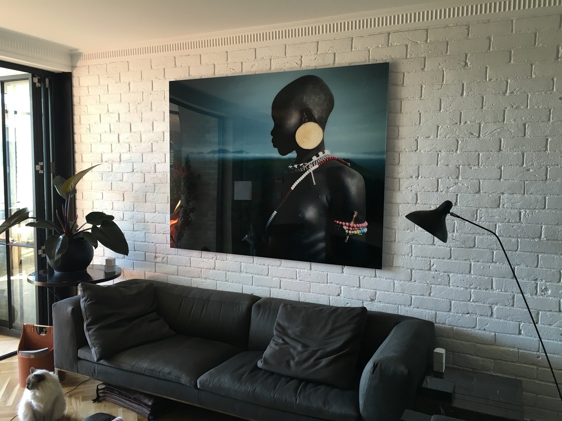 Large artwork hanging on a brick feature wall